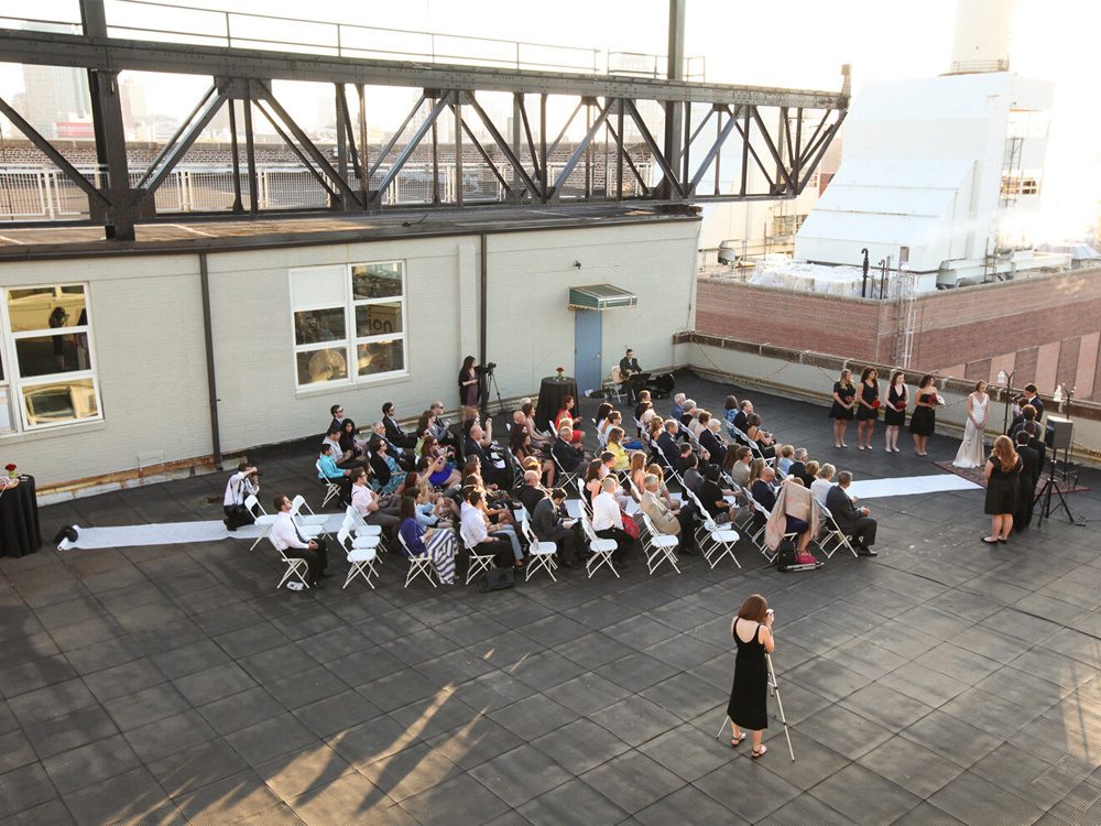 Wedding ceremony in progress of Brooklyn waterfront rooftop even venue at sunset at Ten Ton Studio